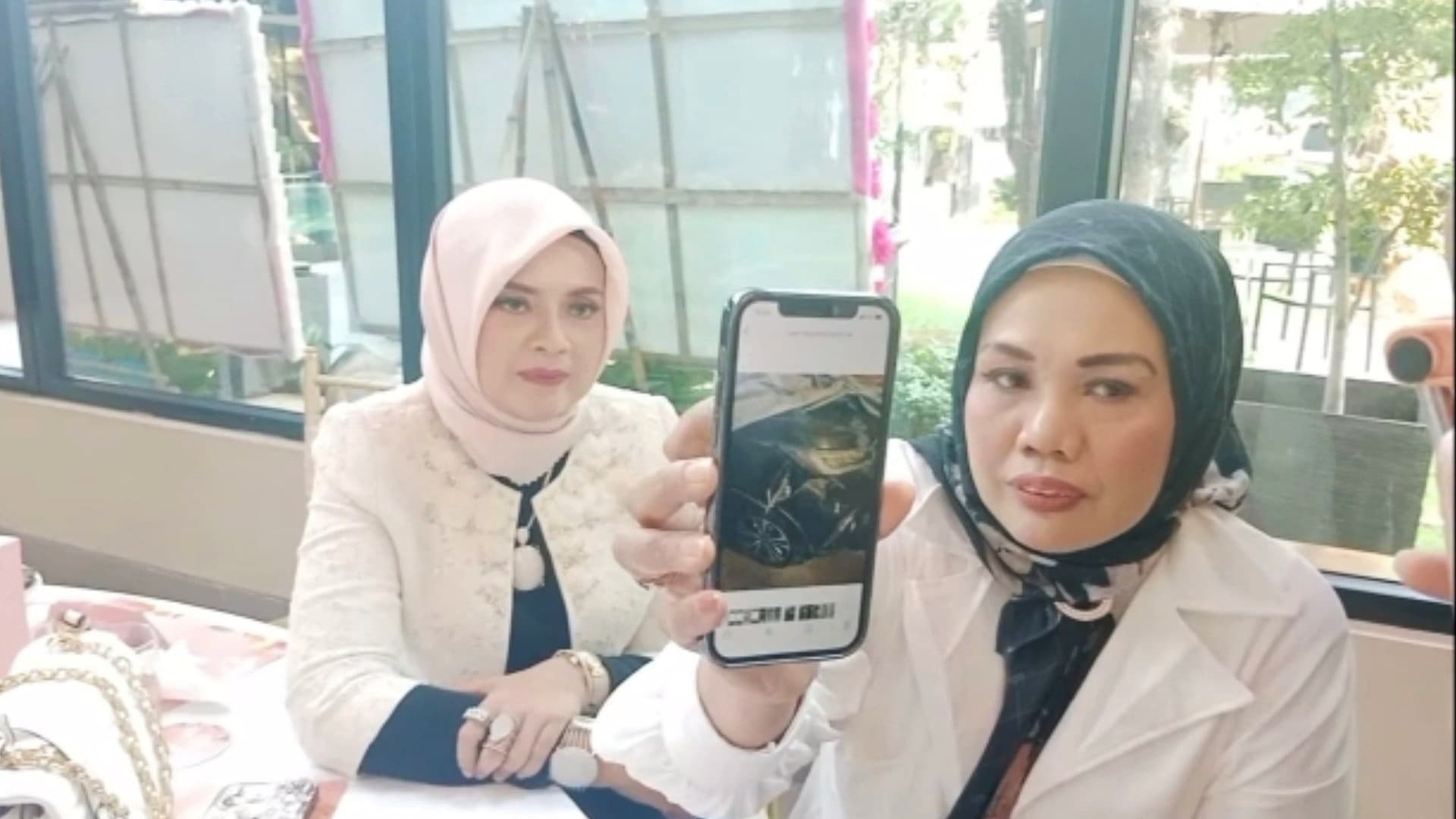 Elly Sugigi memperlihatkan kondisi mobilnya usai ditabrak mobil pengangkut air isi ulang./ Abdul Rahman - Image